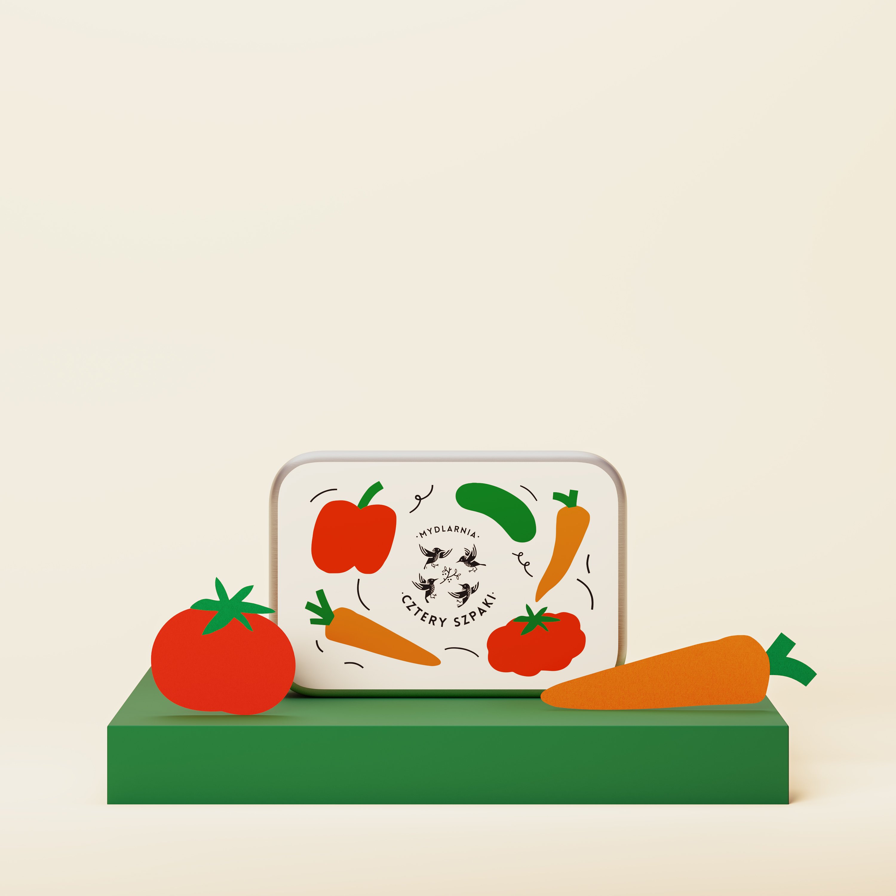 Prostokątna puszka z kolorowymi ilustracjami warzyw, w tym papryką, marchewką i pomidorem, stoi na zielonej platformie. Puszka posiada logo oraz napis „Mydlarnia Cztery Szpaki” na jasnym tle.