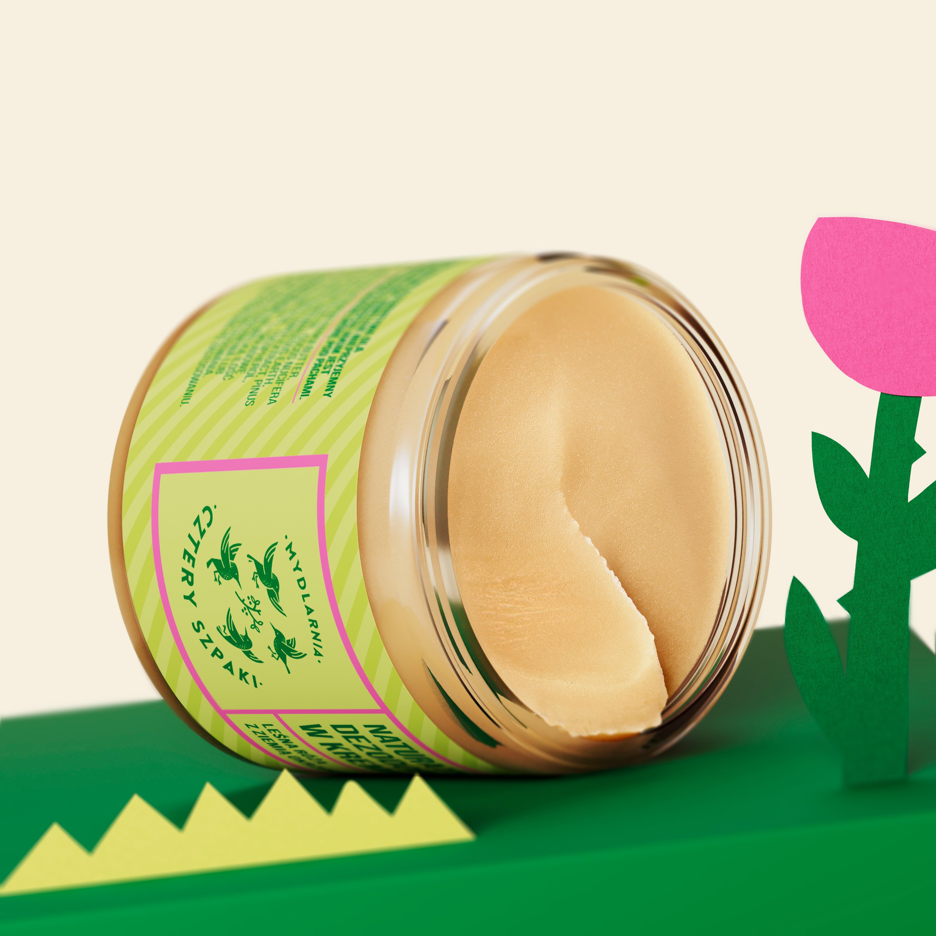 Żywe zdjęcie produktowe słoika z etykietą „Mydlarnia Cztery Szpaki” z naciskiem na naturalną zawartość śmietanki, zestawione na kolorowym, dekoracyjnym tle.