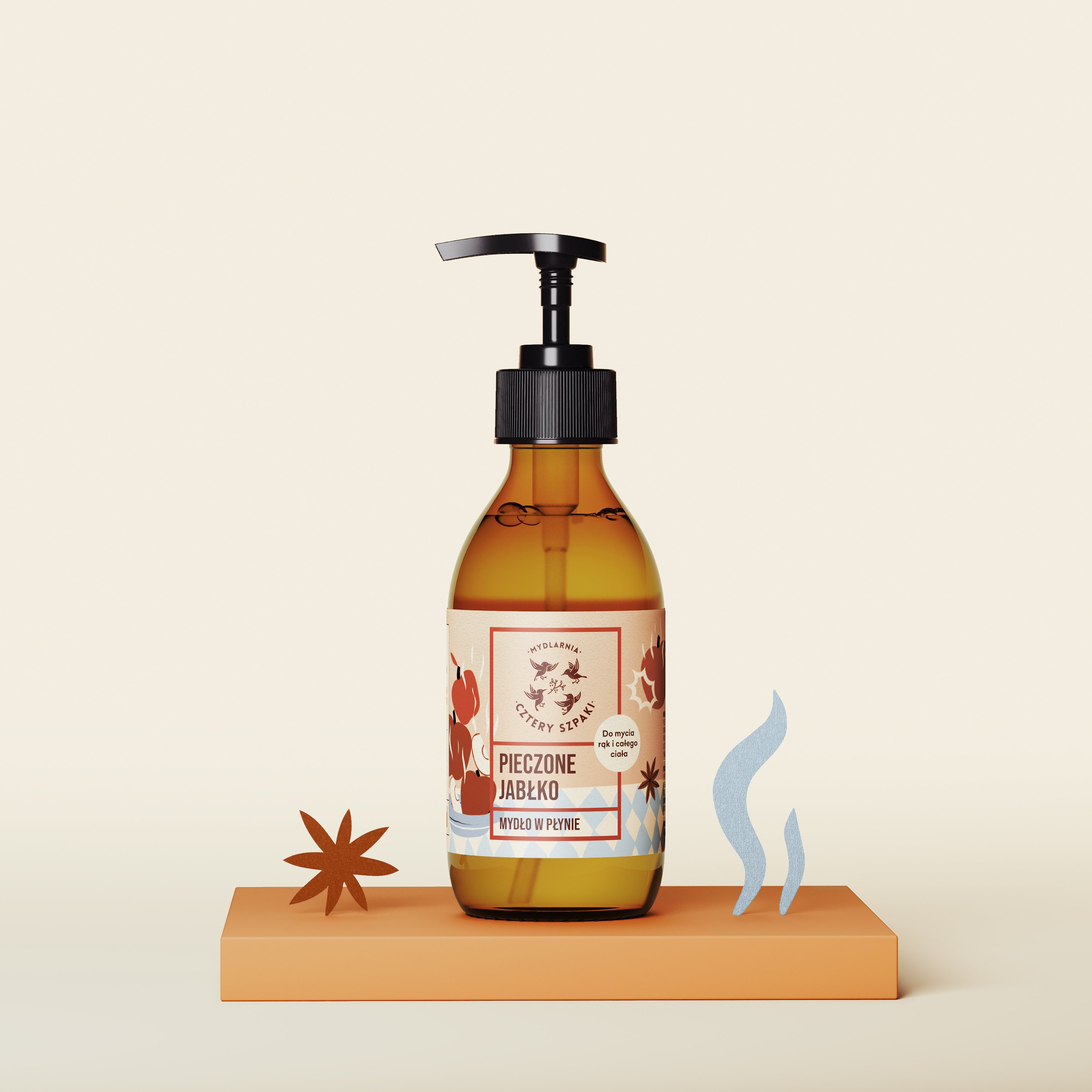 Mydło w płynie w szklanej butelce z pompką z napisem „Pieczone Jabłko” stoi na pomarańczowej platformie, której towarzyszą elementy dekoracyjne, takie jak anyż gwiazdkowaty i falisty niebieski kształt, zestawione na jasnym tle.