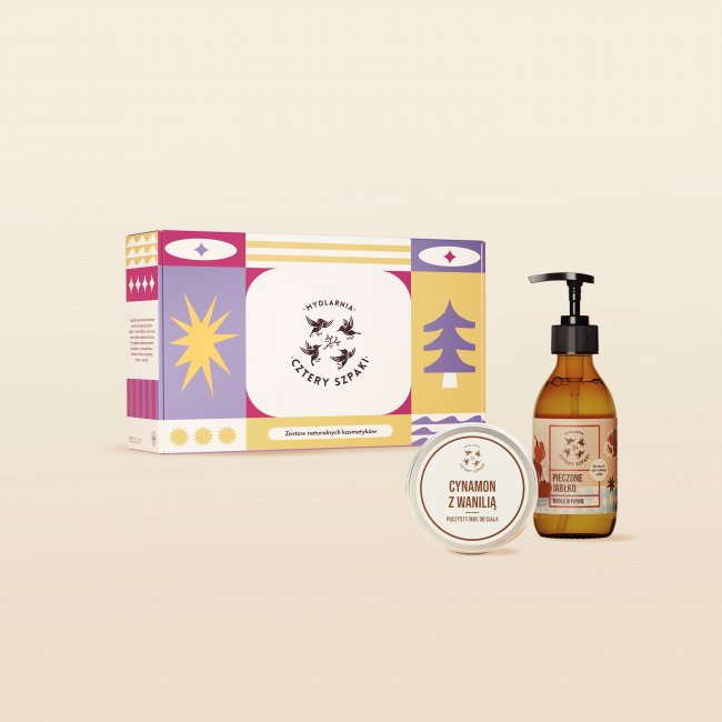 Zestaw kosmetyków naturalnych składający się z prostokątnego pudełka ze świątecznym wzorem w kolorze niebiesko-biało-pomarańczowym z napisem „JABŁKO Z CYNAMONEM”, butelki mydła w płynie z pompką oraz okrągłej puszki musu do ciała.